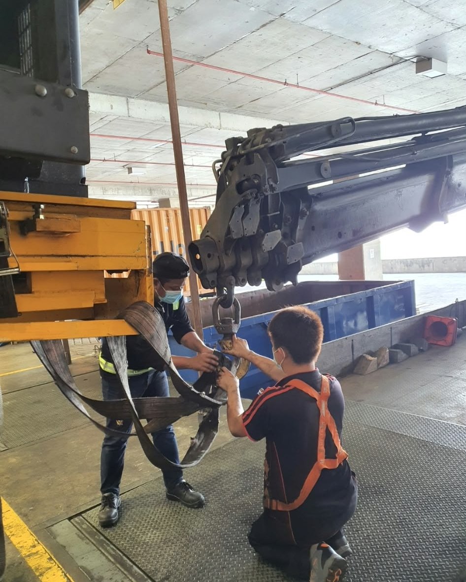 Merah rigging crew attaching lifting gear to a truck