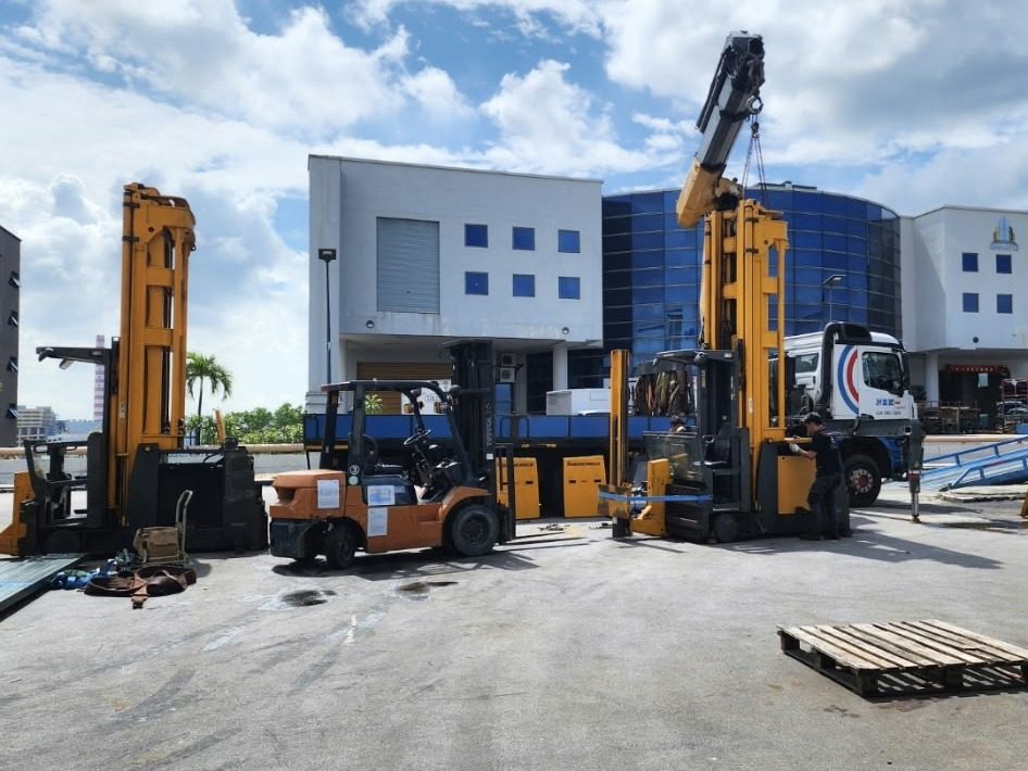 Crane lifting VNA trucks in a yard