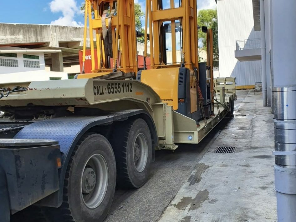 Reach truck loaded on a trailer