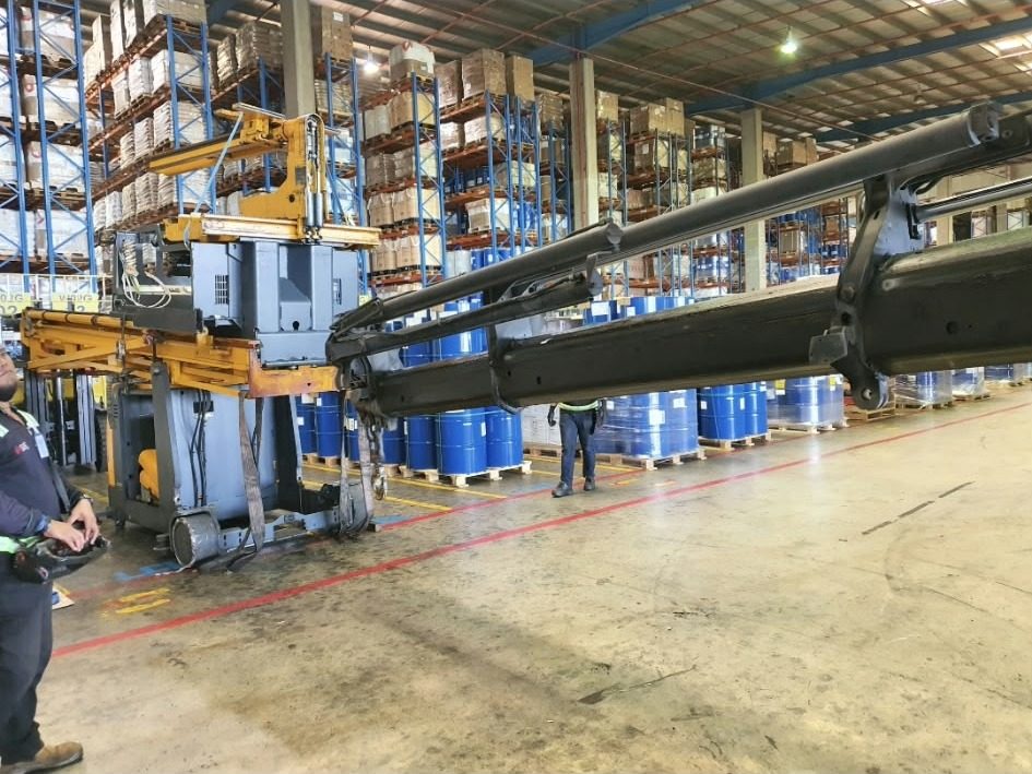 Crane truck lifting a VNA inside a warehouse