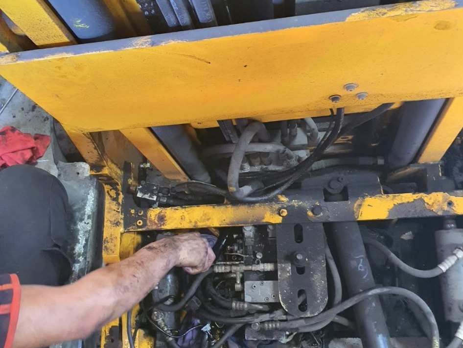 Technician working on forklift mast hydraulics